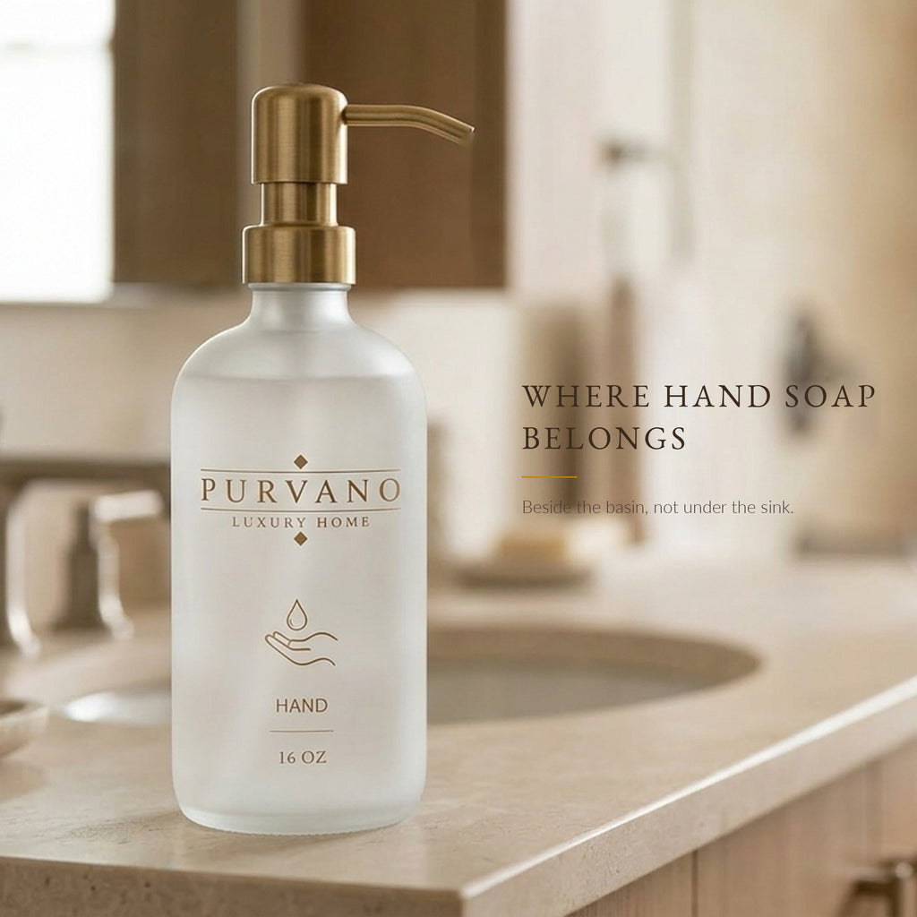 Frosted glass hand soap dispenser beside a bathroom basin