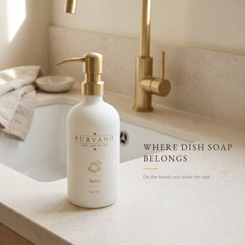 Matte white glass dish soap dispenser on a kitchen bench beside the sink
